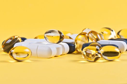 White and black pills on yellow background