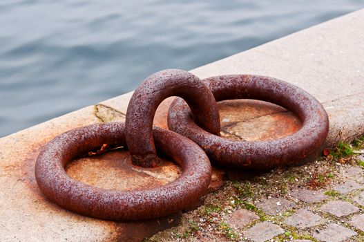 Heavily rusted iron mooring rings with the harbor