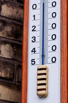 Outdoor thermometer closeup on brick wall