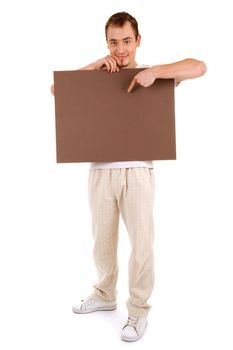 Young man in casual clothes shows by finger on a brown empty board for your text