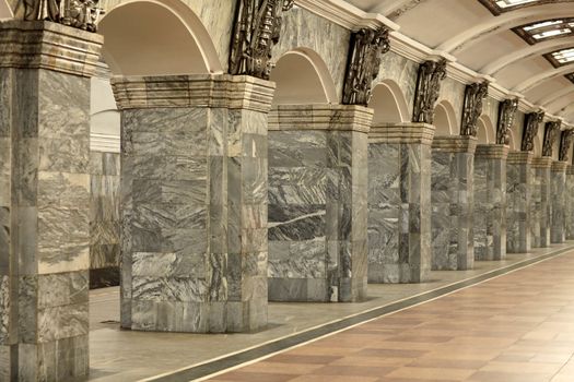 Fragment of the interior with columns lined with gray granite and metal decor