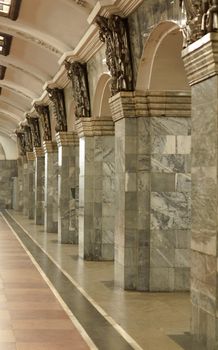 Fragment of the interior with columns lined with gray granite and metal decor