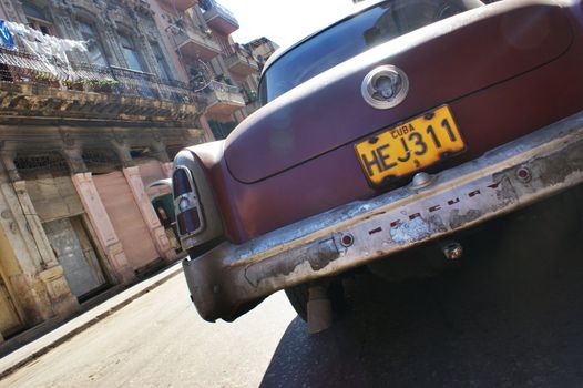 American taxi car parked on the street in Havana, Cuba. A man with bici taxi walking behind