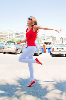Photo of a young, beautiful and cheerful girl who jumps high sunny summer day