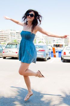 Photo of a young, beautiful and cheerful girl who jumps high sunny summer day