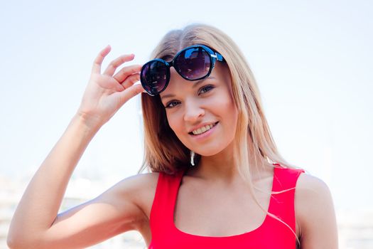 Photo of a young and beautiful girl walking down the street along the marina