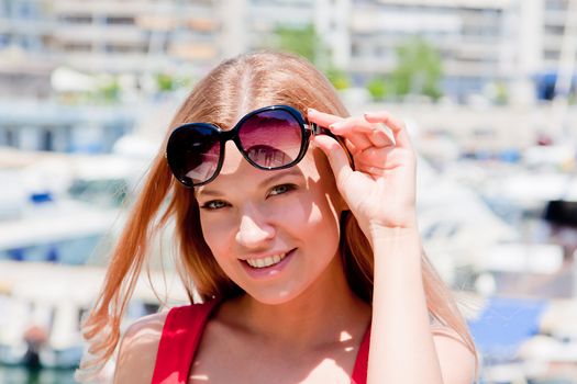 Photo of a young and beautiful girl walking down the street along the marina