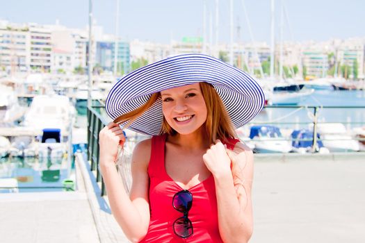 Photo of a young and beautiful girl walking down the street along the marina