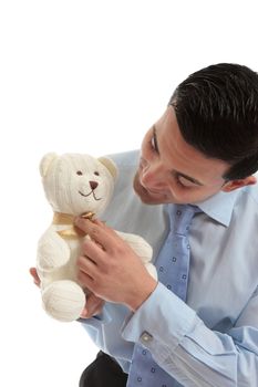 Salesman holding a toy teddy bear and adjusting its ribbon bow.
