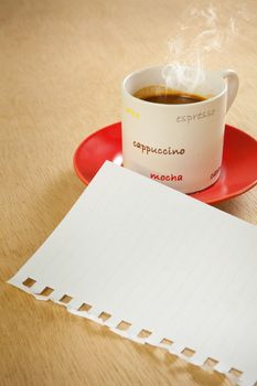 cup of hot coffee and note paper on wood background