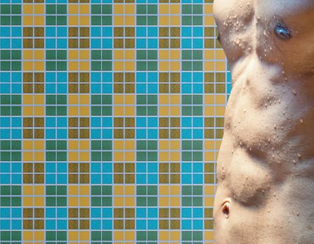 Wet torso with water drops against mosaic wall
