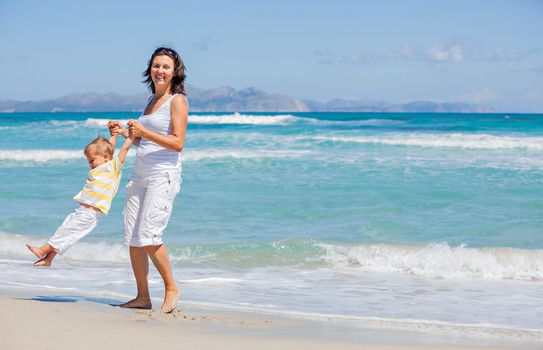 Mother and son having fun on tropical white sand beach