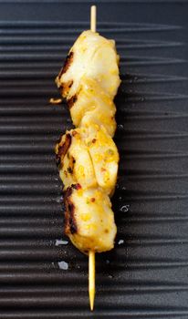 delicious fresh fish spear grilling on barbecue