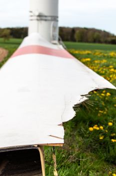 alternative energy source. wind turbine with broken spare rotor blade lying in front