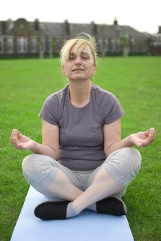 middle aged woman keeping fit with exercises in a park