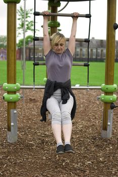 middle aged woman keeping fit with exercises in a park