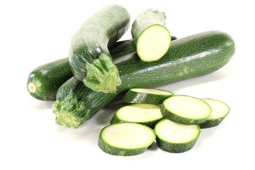 fresh sliced and whole zucchini on a light background