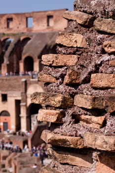 A Coloseum ruins with tourists in Rome
