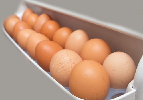 closeup of a pile of brown eggs in the fridge 