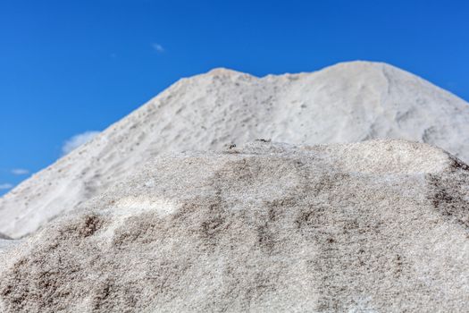 Big pile of freshly mined salt, set against a blue sky