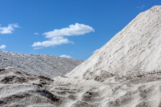 Big pile of freshly mined salt, set against a blue sky