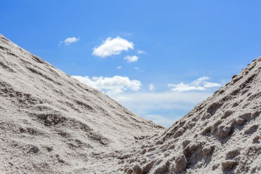 Big pile of freshly mined salt, set against a blue sky