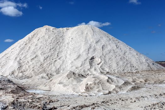 Big pile of freshly mined salt, set against a blue sky