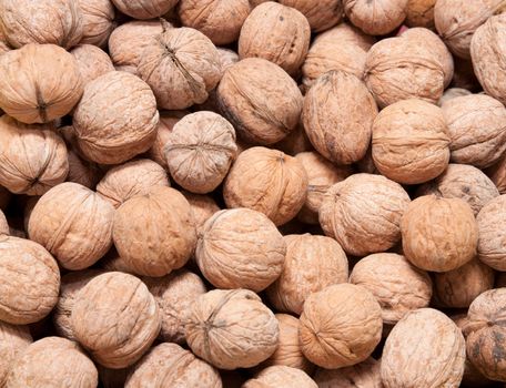 Brown raw walnuts textured background 