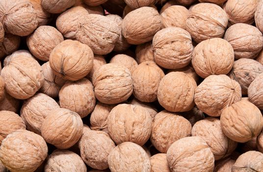 Brown raw walnuts textured background 