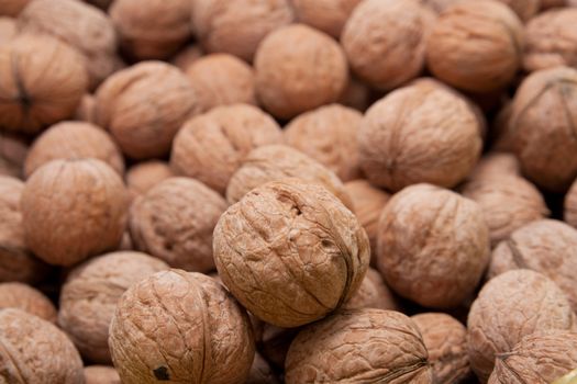 Brown raw walnuts textured background 