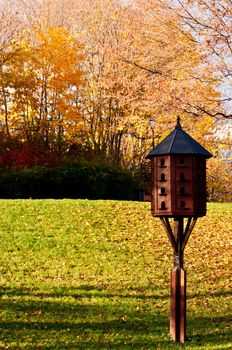 Bird house in city park at fall autumn