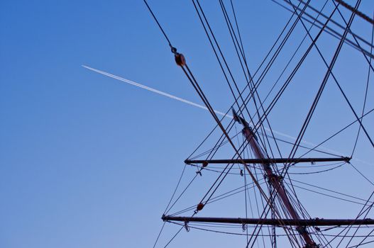 Ship mast with airplane trace on background