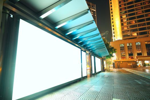 Blank billboard on bus stop at night 