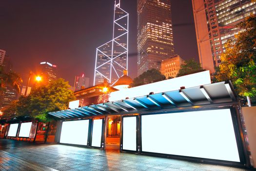Blank billboard on bus stop at night 