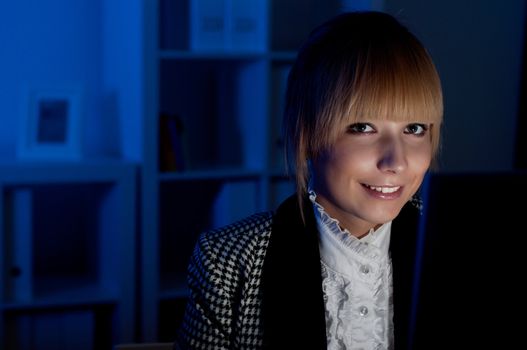 beautiful young business woman working at night in the office