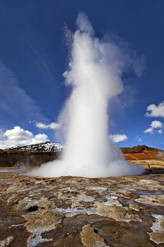 Icelandic Geyser erupts, with blue sky in the background