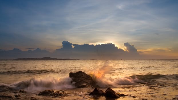 The waves breaking on the rocks in the evening