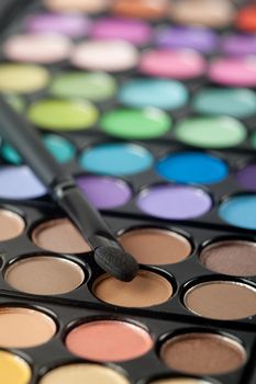 A colorful image on an eyeshadow pallet with a brush.