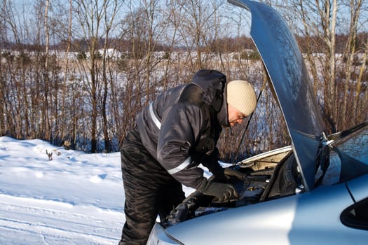 man checked the broken car engine in cold winter day