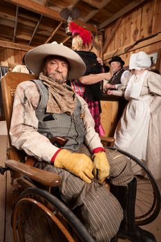 Injured mature cowboy in wheelchair at old west saloon