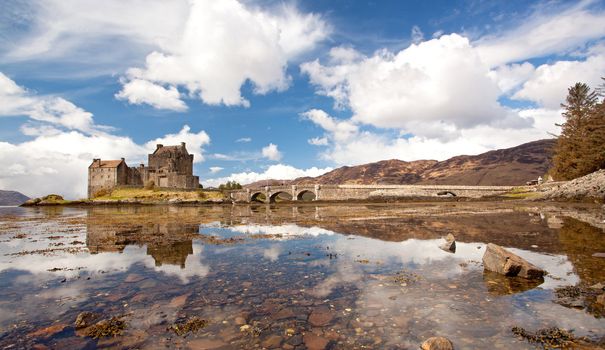 Panorama of Eilean Donan Castle and its Reflection on sea, Highland Scotland.
