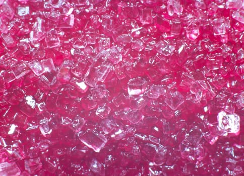 A macro picture of white sugar colored with pink color