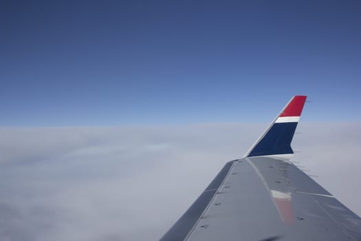 Shot of a Boeing 737 wing at cruising altitude over clouds
