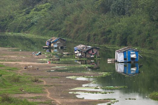 Dead arm of river houses a few boats used as poor living shelters.