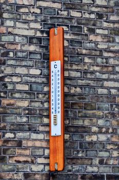 Outdoor thermometer on background brick wall