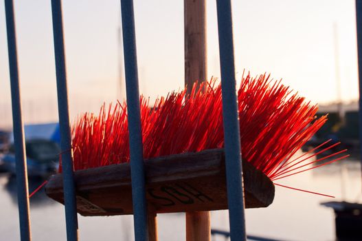 Red mop behind fence broom highlighted