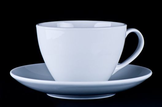 White mug on saucer black background