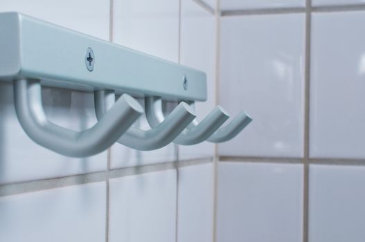 Brushed metal silver towel hanger on rest room wall