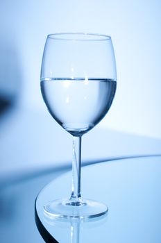Glass of white wine on the table on blue background
