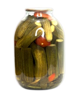 In a glass jar marinaded cucumbers and tomatoes on a white background 